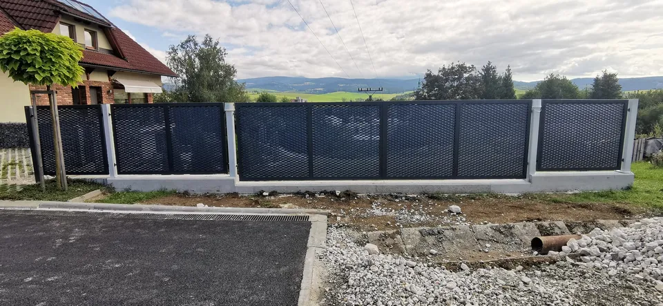 Plot z ťahokovu na podmurovke, v pozadí oravské kopce