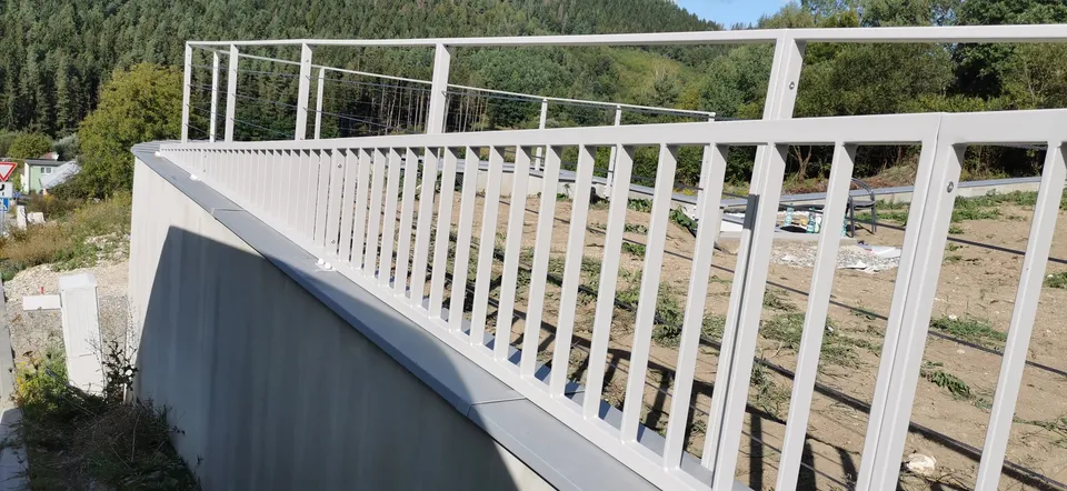 Zábradlie so zvislými priečkami nad oporným múrom