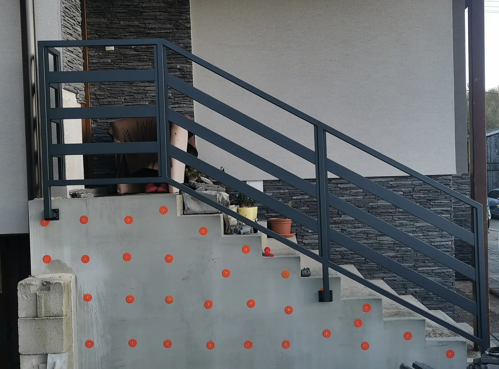 Antracitové schodiskové zábradlie s vodorovnými priečkami pri dome